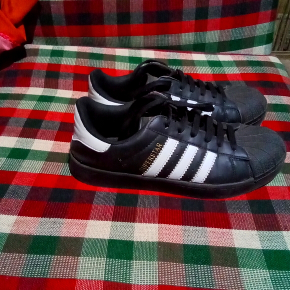 adidas Shoes - This is an Adidas Superstar. Size is UK 4. The color is black with white stripes